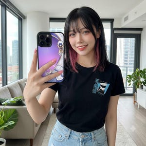 May include: A black short-sleeved t-shirt featuring a small graphic print on the left chest area. The graphic includes a blue square with an illustration of a character with white hair and a blindfold, accompanied by Japanese text and the word The Strongest.