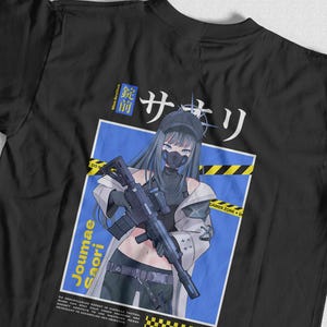 以下が含まれることがあります： 黒いTシャツ。青い髪、マスク、戦術的な装備をしたアニメキャラクターがライフルを持っているグラフィック。 「Joumae Saori」と日本語のテキストが含まれています。 青と黄色のハザードストライプも表示されています。
