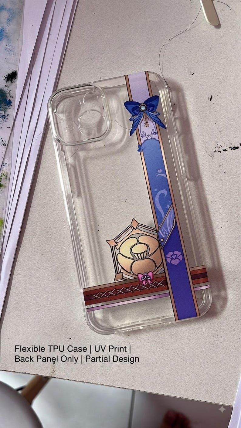 May include: A clear flexible TPU phone case featuring a vertical purple band with a blue bow, a gold-toned geometric emblem, and a cross-stitched pattern. The text on the case reads: Flexible TPU Case | UV Print | Back Panel Only | Partial Design.