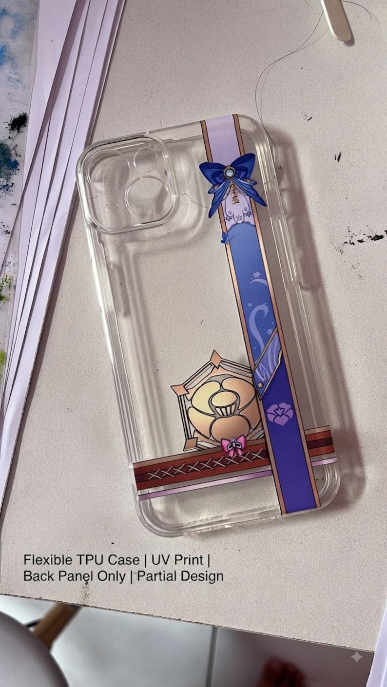 May include: A clear flexible TPU phone case featuring a vertical purple band with a blue bow, a gold-toned geometric emblem, and a cross-stitched pattern. The text on the case reads: Flexible TPU Case | UV Print | Back Panel Only | Partial Design.