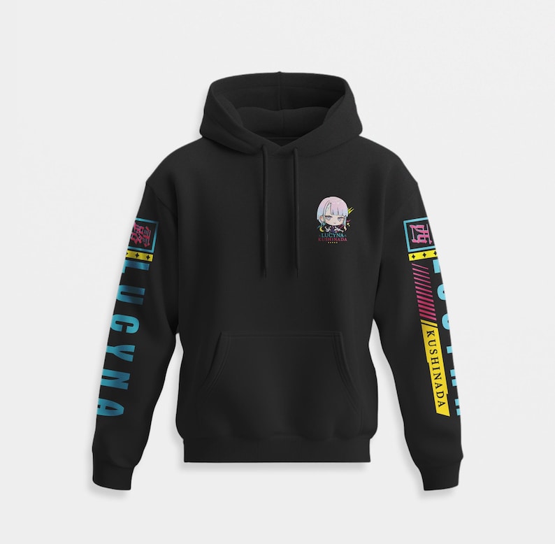 K&ouml;nnte beinhalten: Ein schwarzer Kapuzenpullover mit einer kleinen Chibi-Grafik auf der linken Brust und dem Text LUCYNA KUSHINADA. Beide &Auml;rmel zeigen den vertikalen Schriftzug LUCYNA KUSHINADA in Blau und Gelb, erg&auml;nzt durch geometrische Akzentmuster.