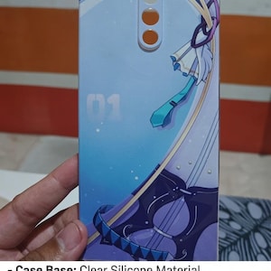 May include: A rectangular phone case with a light blue and purple anime-style graphic print. The design features the number 01, a teal necktie, and a stringed instrument. The case has circular cutouts at the top for camera and sensor components.