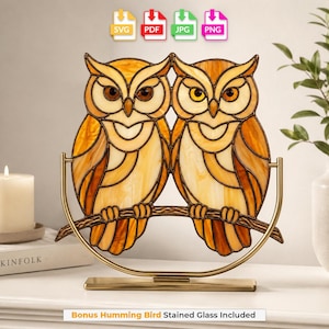 May include: A stained glass art piece featuring two owls perched on a branch, rendered in shades of amber and cream. The design is supported by a gold-toned metal frame. Text icons for SVG, PDF, JPG, and PNG are visible at the top of the image.
