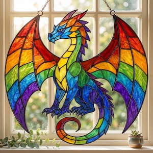 Può includere: Un acchiappasole in vetro colorato a forma di drago con ali spiegate. Il drago presenta una vivace tavolozza di colori arcobaleno che include segmenti di vetro rosso, arancione, giallo, verde, blu e viola uniti da linee di piombo scure.