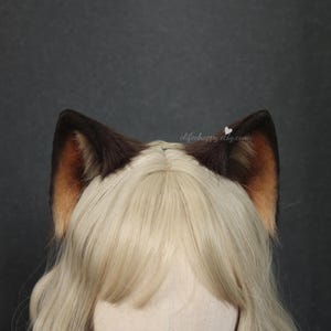 May include: A set of brown and tan faux fur cat ears. The ears are dark brown on the outside and tan on the inside. The ears are attached to a blonde wig. The Etsy shop name "elifeehappy.etsy.com" is visible on the image.