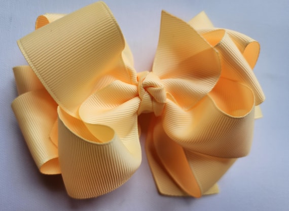 Six  inch triple layer  boutique hair bow on a hair clip. Color: Buttercream