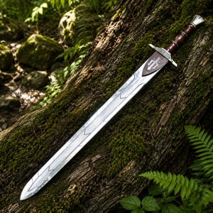 May include: A long, silver sword with a brown leather-wrapped handle and a decorative shield-shaped emblem near the blade's base. The sword rests on a moss-covered log, surrounded by greenery.