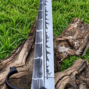 May include: A sword with a long, double-edged blade featuring a dark, cracked-pattern finish on one side and a jagged, thorn-like design along the center ridge. The hilt has a black metal crossguard and a dark, spiraled, reddish-brown handle.