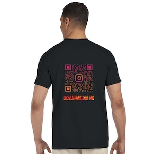 Könnte beinhalten: Schwarzes T-Shirt mit einem QR-Code-Design in Pink, Orange und Gelb. Das Instagram-Logo befindet sich in der Mitte des QR-Codes. Der Text "SCAN ME, DM ME" steht unter dem QR-Code.