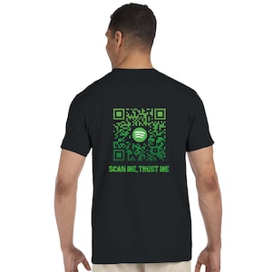 Könnte beinhalten: Schwarzes T-Shirt mit einem grünen QR-Code-Design und dem Spotify-Logo. Der Text "SCAN ME, TRUST ME" ist unter dem Code aufgedruckt. Das T-Shirt hat einen Rundhalsausschnitt und kurze Ärmel.