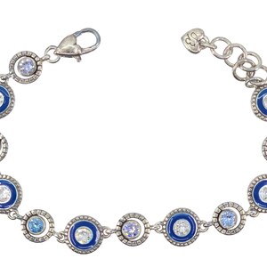 May include: Silver-toned bracelet featuring alternating blue enamel and clear crystal accents. The bracelet has a series of circular links with a mix of light blue and clear crystals. The clasp is a lobster claw style.