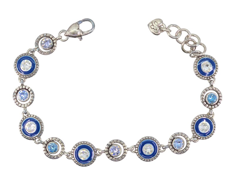 May include: Silver-toned bracelet featuring alternating blue enamel and clear crystal accents. The bracelet has a series of circular links with a mix of light blue and clear crystals. The clasp is a lobster claw style.