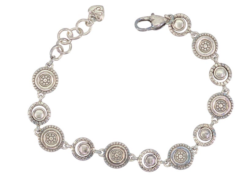 May include: Silver-toned bracelet featuring a series of circular, decorative links. Each link has a central design surrounded by a beaded border. The bracelet has a lobster clasp closure and an adjustable chain.