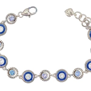 May include: Silver-toned bracelet featuring alternating blue enamel and clear crystal circle designs. The bracelet has a lobster clasp closure and a series of small, round, clear and blue crystals. A stylish piece of jewelry.