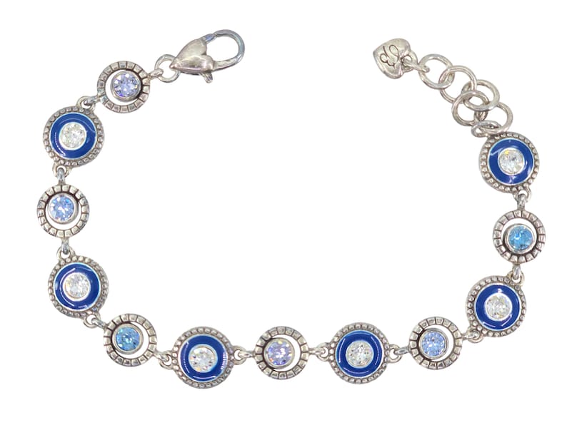 May include: Silver-toned bracelet featuring alternating blue enamel and clear crystal circle designs. The bracelet has a lobster clasp closure and a series of small, round, clear and blue crystals. A stylish piece of jewelry.