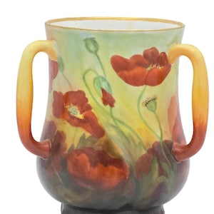 Puede incluir: Jarrón de cerámica pintado a mano con dos asas, con un diseño floral de amapolas rojas sobre un fondo amarillo y verde. El jarrón tiene un borde dorado y una base oscura, mostrando una estética antigua.