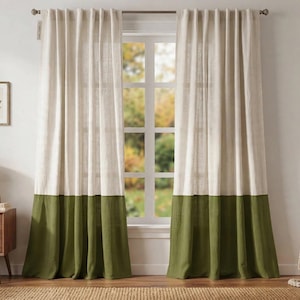 Puede incluir: Un par de cortinas de cuerpo entero con un diseño de bloques de dos tonos. La sección superior es de color crema claro, mientras que la sección inferior es de un verde oliva sólido. Las cortinas cuelgan de una barra de metal y tienen textura tejida.