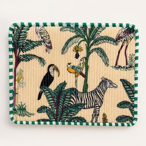 May include: Rectangular beige fabric with a green and white striped border. The fabric features a jungle scene with a zebra, toucan, parrots, and other tropical birds and plants.