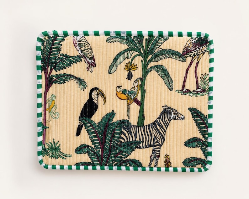 May include: Rectangular beige fabric with a green and white striped border. The fabric features a jungle scene with a zebra, toucan, parrots, and other tropical birds and plants.