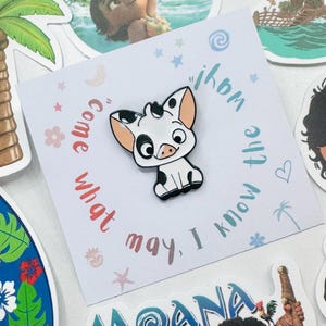 Puede incluir: Un pin de esmalte blanco y negro con un cerdo de dibujos animados con orejas rosas y una cara sonriente. El pin est&aacute; sobre una tarjeta blanca con el texto "Come what may, I know the way" en un dise&ntilde;o circular.