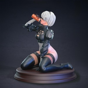 Puede incluir: Figura de un personaje arrodillado con cabello blanco, vistiendo un atuendo blanco y negro, bebiendo de una lata naranja. La figura está sobre una base circular marrón, con un fondo oscuro.