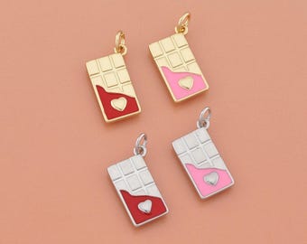 Può includere: Quattro ciondoli a forma di barretta di cioccolato con dettagli a cuore. Due sono dorati con accenti rossi e rosa, e due sono argentati con accenti rossi e rosa. Ogni ciondolo ha un piccolo anello.