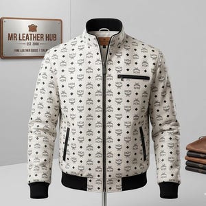 May include: A cream-colored jacket featuring a repeating black MCM logo pattern, a full-length front zipper, a stand-up collar, and black ribbed cuffs and hem. The jacket includes a zippered chest pocket and two side pockets with black trim details.