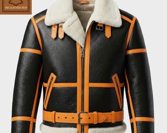 Può includere: Giacca in pelle nera con finiture arancioni e colletto e fodera in montone color crema. La giacca ha una cerniera frontale, una cintura in vita e fibbie sulle spalle. È visibile il logo "MR LEATHER HUB".