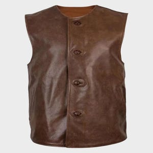 May include: A brown leather vest with a button-up front. The vest has a round neckline and four buttons. The leather has a slightly distressed appearance, with variations in color and texture.