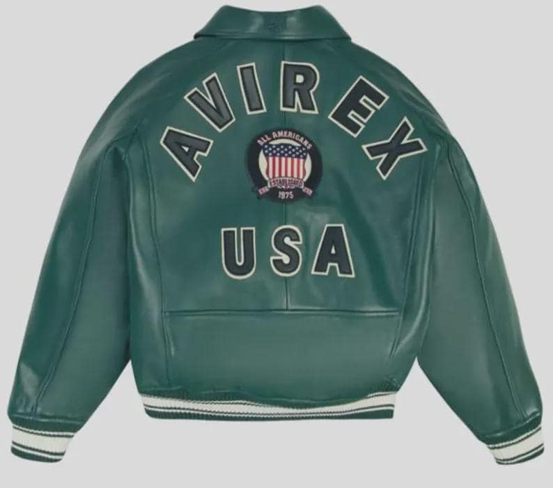 Puede incluir: Chaqueta de cuero verde con ribetes blancos en los pu&ntilde;os y el dobladillo. La parte trasera de la chaqueta presenta la palabra "AVIREX" en letras blancas en bloque sobre un parche circular con las palabras "ALL AMERICANS ESTABLISHED 1975" y la bandera de EE. UU. Debajo, la palabra "USA".