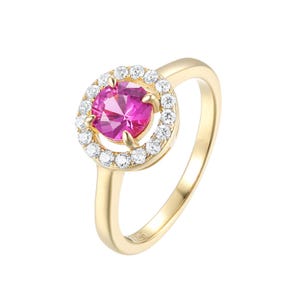 Op de afbeelding: Een gouden ring met een ronde, felroze middensteen die door vier pootjes wordt vastgehouden. De middensteen is omringd door een cirkelvormige halo van kleine, heldere, rond geslepen witte steentjes. De ringband is van glad, gepolijst goud met een 925-stempel.