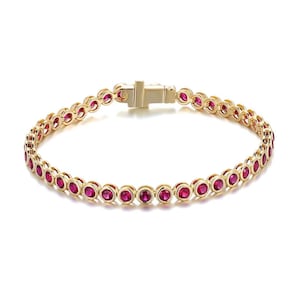 Peut inclure: Un bracelet doré orné d'une série de pierres précieuses rouges vives. Le bracelet est doté d'un fermoir sécurisé et d'un design élégant. Les pierres précieuses sont espacées uniformément le long du bracelet.