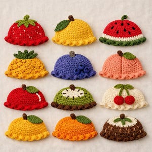 Puede incluir: Una colección de doce gorros de ganchillo con temática de frutas dispuestos en una cuadrícula. Los diseños incluyen fresa, limón, sandía, piña, arándano, melocotón, manzana, kiwi, cereza, plátano, naranja y patrones de frutas con chocolate.