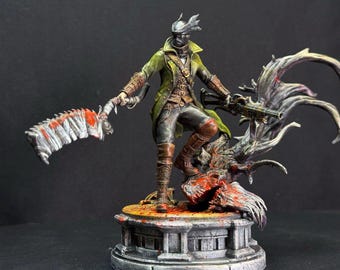 May include: A hand-painted miniature figurine of a hunter character wearing a long olive green coat, dark trousers, and brown boots. The figure holds a large serrated blade with red blood-like paint and a firearm, standing on a stone-like base.