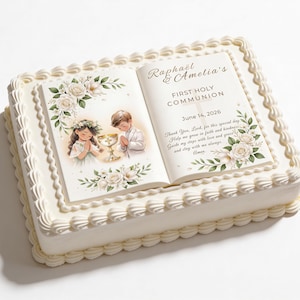 Könnte beinhalten: Ein rechteckiger Kuchen mit weißem Zuckerguss und dekorativen Rändern. Der Kuchen zeigt ein essbares Bild eines offenen Buches mit dem Text "Raphael & Amelia's FIRST HOLY COMMUNION June 14, 2026". Das Bild enthält Illustrationen eines Jungen und eines Mädchens.