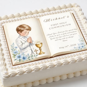 Puede incluir: Un pastel rectangular blanco decorado con glaseado blanco, perlas y una imagen comestible impresa. La imagen representa a un niño con un traje blanco rezando ante un cáliz y una cruz, con el texto "Primera Comunión de Michael" y la fecha 14 de mayo de 2026.