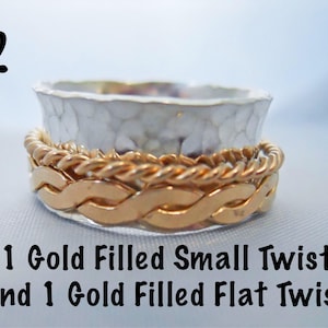 May include: A silver ring with a hammered texture, topped with two gold filled bands. One band is a flat twist and the other is a small twist.