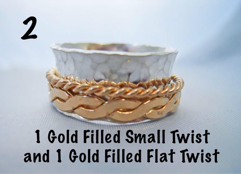 May include: A silver ring with a hammered texture, topped with two gold filled bands. One band is a flat twist and the other is a small twist.