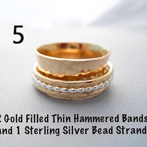 May include: Three gold filled rings stacked on top of each other. The top two rings are thin and hammered. The bottom ring is a sterling silver bead strand.  2 Gold Filled Thin Hammered Bands and 1 Sterling Silver Bead Strand