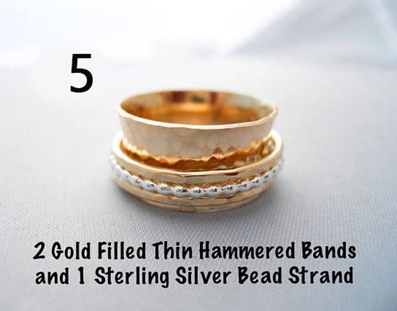 May include: Three gold filled rings stacked on top of each other. The top two rings are thin and hammered. The bottom ring is a sterling silver bead strand.  2 Gold Filled Thin Hammered Bands and 1 Sterling Silver Bead Strand