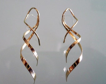 May include: A pair of gold-toned earrings with a twisted, spiral design.