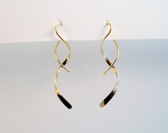 May include: A pair of gold-toned, twisted, wire earrings. The earrings are long and dangle.