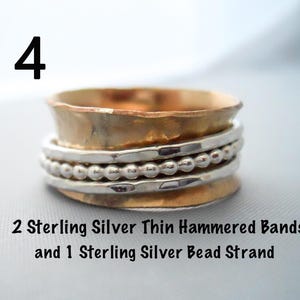 May include: A silver spinner ring with two thin hammered bands and a silver bead strand. The ring is made of sterling silver.