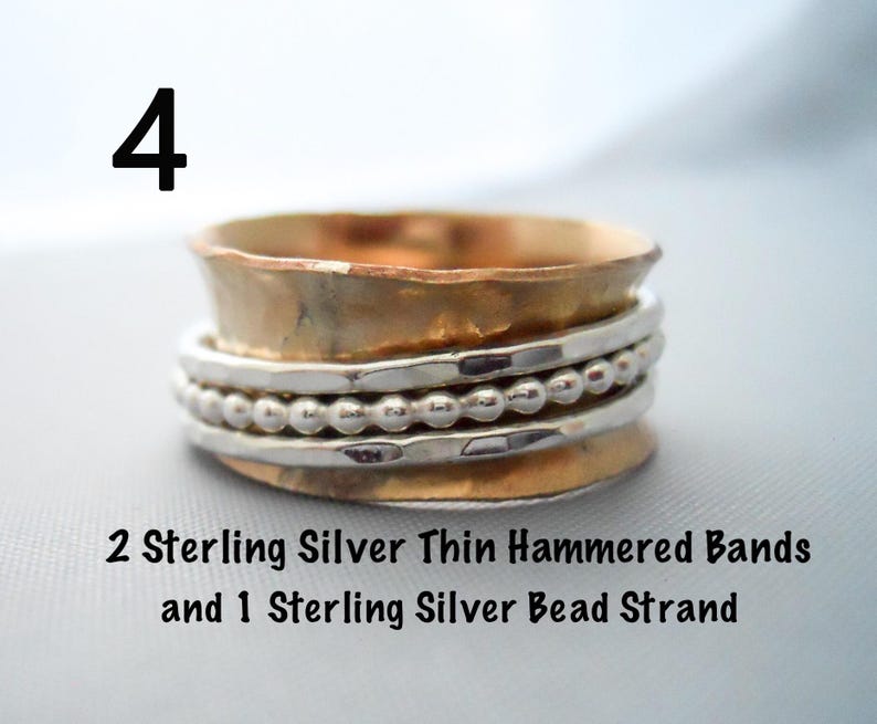 May include: A silver spinner ring with two thin hammered bands and a silver bead strand. The ring is made of sterling silver.