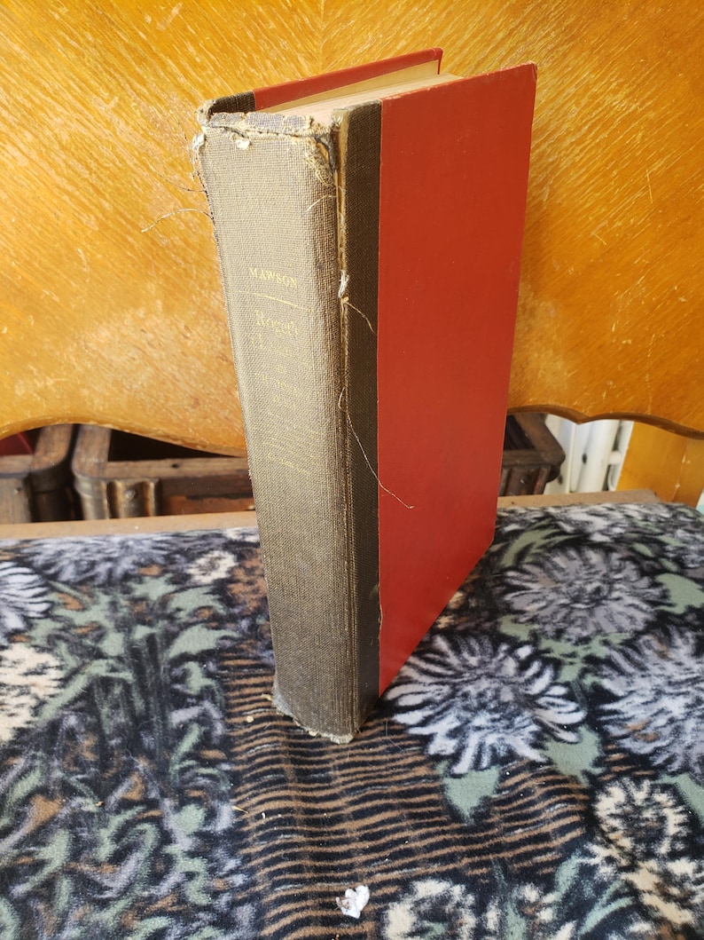 May include: A hardback book with a dark grey fabric spine and bright red covers. The spine features gold lettering that reads Mawson and Roget. The fabric on the spine shows signs of wear and fraying along the edges and top corner.