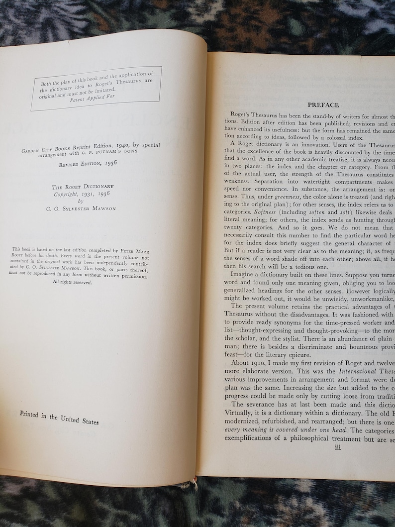 May include: An open book displaying the copyright page on the left and the preface on the right. The text includes Garden City Books Reprint Edition 1940, Revised Edition 1936, The Roget Dictionary, and C. O. Sylvester Mawson. The pages are off-white.