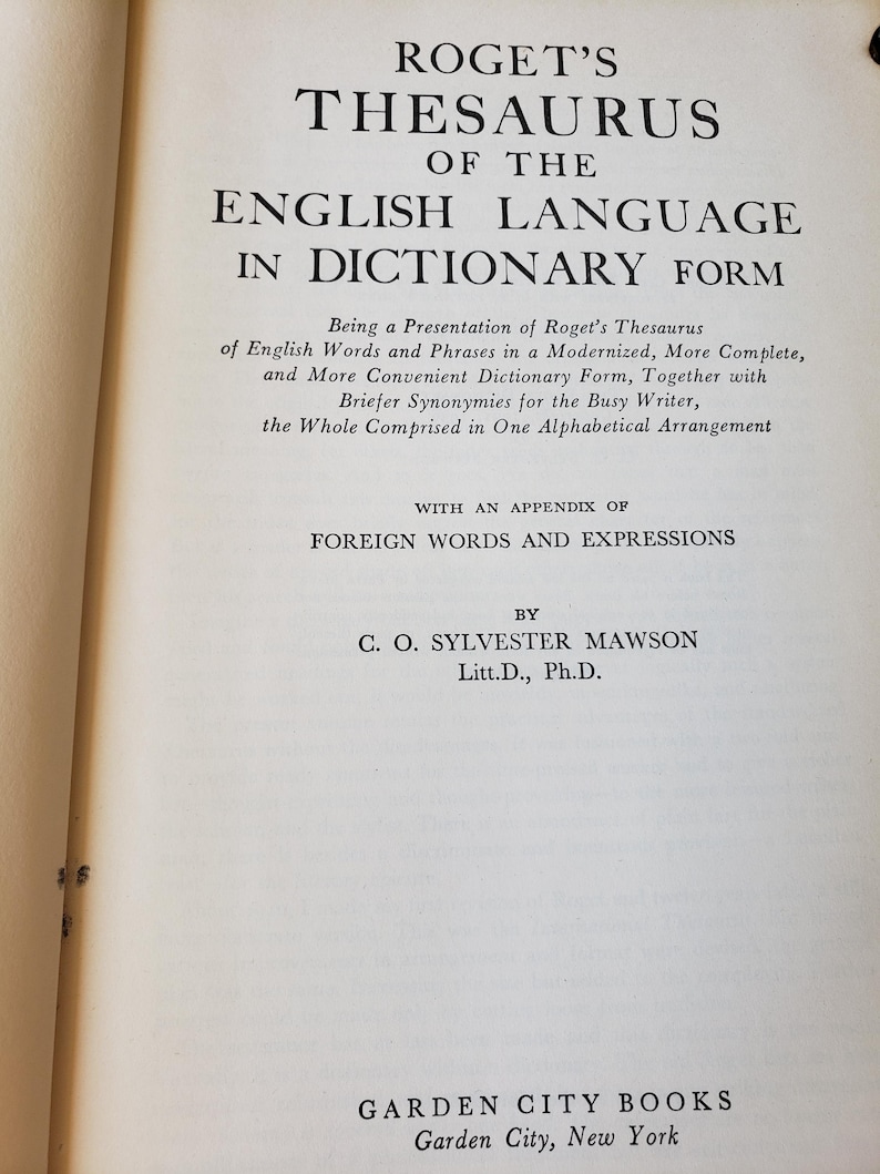 May include: The title page of Roget's Thesaurus of the English Language in Dictionary Form by C. O. Sylvester Mawson, Litt.D., Ph.D., published by Garden City Books, Garden City, New York, featuring black text on a cream-coloured paper page.
