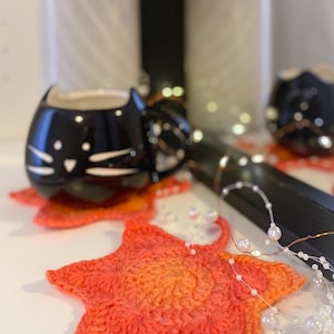 Large crochet maple leaf coaster made with ombré autumn yarn. Handmade fall home décor perfect for table settings, seasonal decorations, or as a unique crochet gift