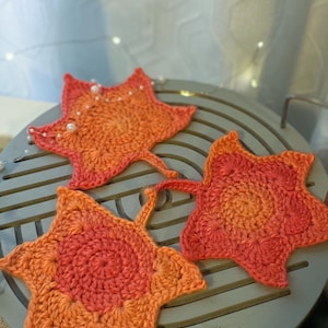 Large crochet maple leaf coaster made with ombré autumn yarn. Handmade fall home décor perfect for table settings, seasonal decorations, or as a unique crochet gift