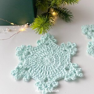 Crochet snowflake coaster made with cotton yarn, perfect as a Christmas table decoration, tea or coffee cup mat, or handmade gift. Digital crochet pattern PDF for beginners and intermediate crocheters.